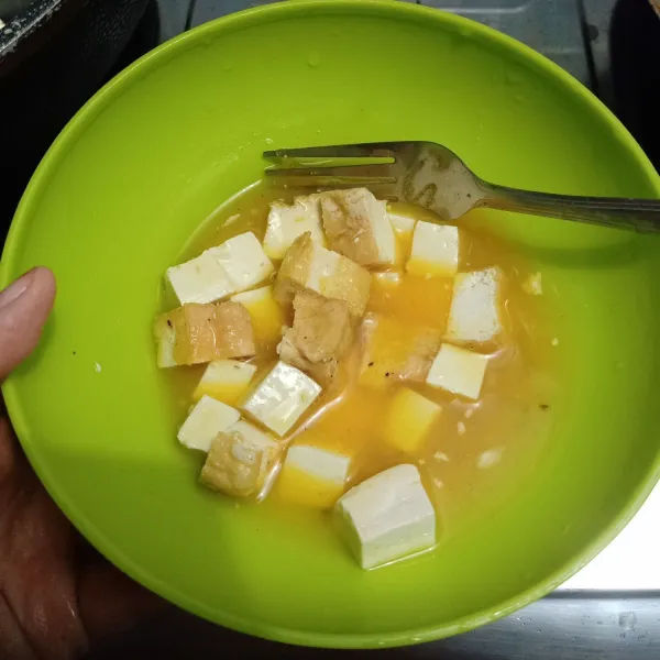 Siapkan di dalam mangkuk kocokan telur, garam dan penyedap lalu masukan potongan tahu aduk rata. Jangan terlalu kuat agar tahu tetap utuh.