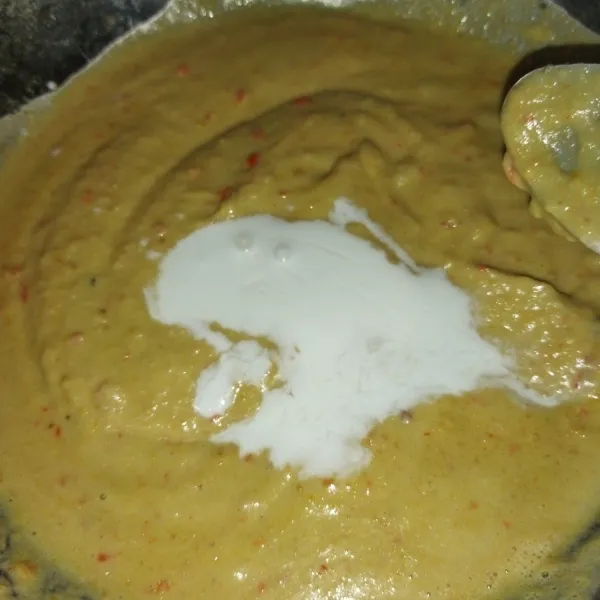 Lalu blender kacang tanah, cabe merah, cabe rawit, bawang putih, kentang rebus, gula merah, air asam jawa, blender dengan ditambah 200 ml air. Lalu tuang ke wajan, tambahkan santan kental.