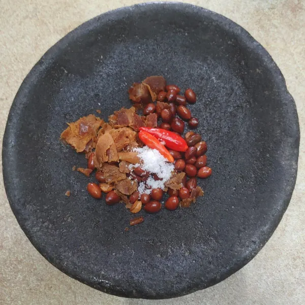 Siapkan bumbu dalam layah/ cobek. Tambahkan 2 sendok makan kacang tanah goreng, cabe rawit, gula merah, cabe rawit dan garam. Haluskan.