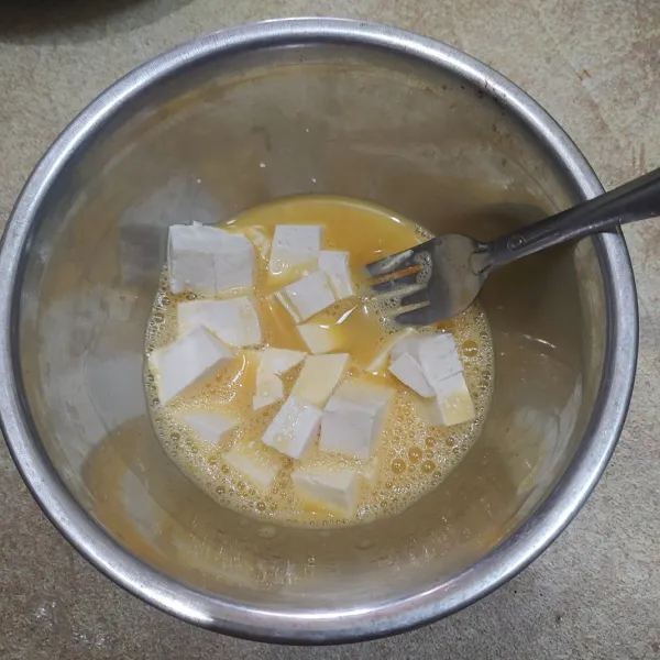 Kocok telur tambahkan sedikit garam dan masukan potongan tahu.