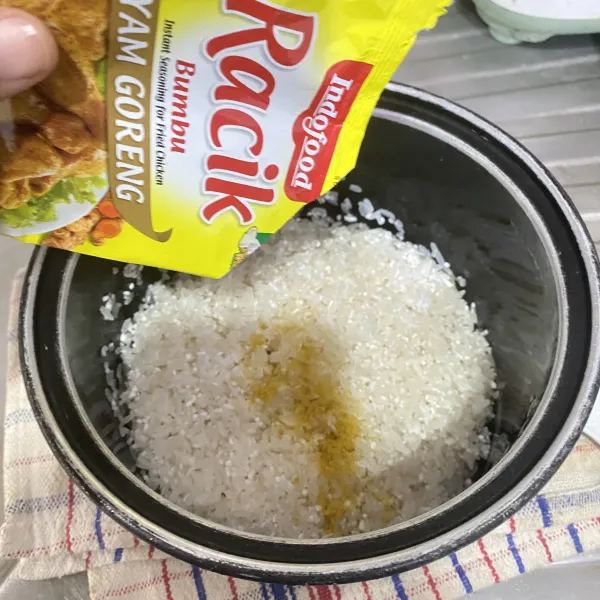 Cuci bersih beras dan beri bumbu racik, aduk sampai tercampur rata.