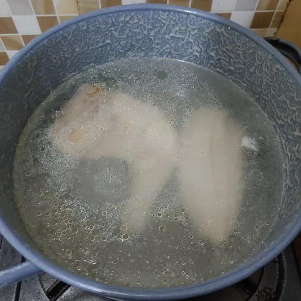 Panaskan air hingga mendidih, lalu masukkan potongan daging ayam.