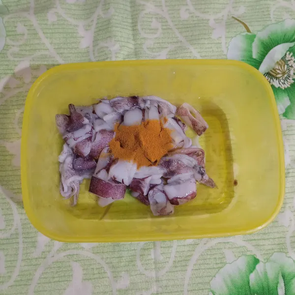 Bersihkan tinta kulit cumi. Bilas hingga bersih. Taburkan kunyit, garam dan kaldu bubuk.