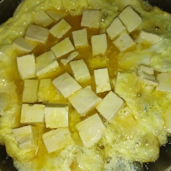 Panaskan minyak goreng, lalu masukkan campuran tahu dan telur. Masak hingga bagian bawahnya matang, lalu balik perlahan. Masak hingga bagian lainnya matang.