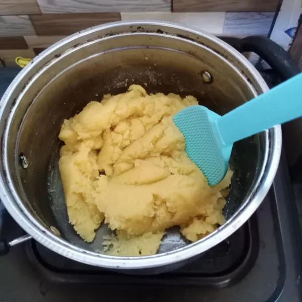 Kemudian kecilkan api lalu masukkan terigu. Aduk terus sampai adonan kalis.