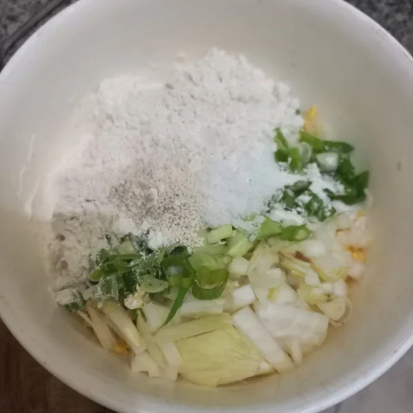 Tambahkan tepung terigu, irisan bawang daun, garam, kaldu jamur dan merica bubuk, aduk rata.