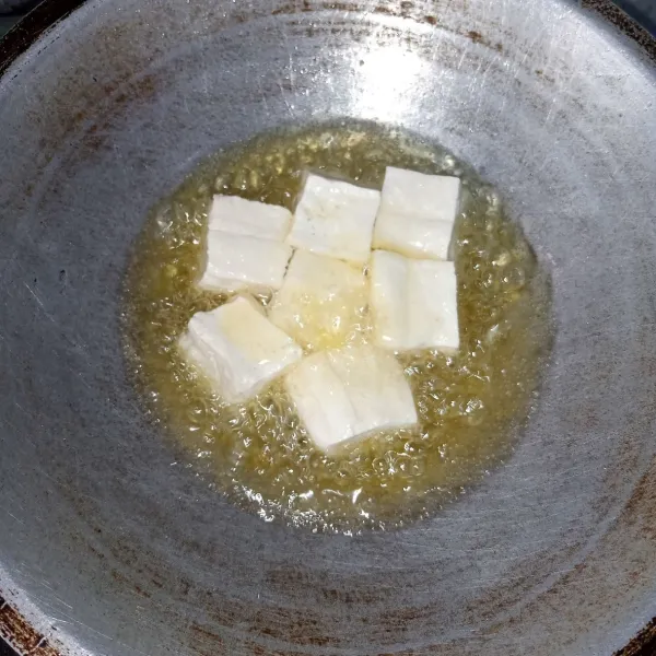 Goreng tahu sampai matang. Angkat, tiriskan dan potong-potong.