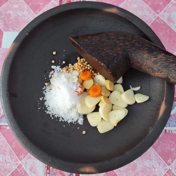 Uleg bawang putih, kunyit, jahe, ketumbar dan garam. Tambahkan sedikit air.