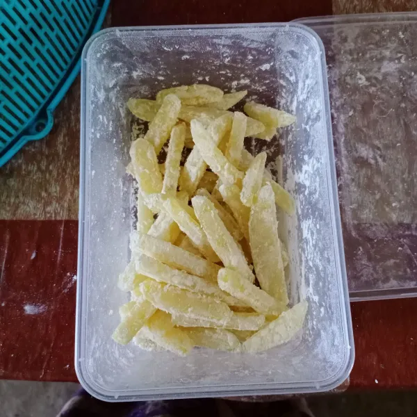 Tutup wadah lalu kocok sampai kentang terbalut rata dengan tepung.