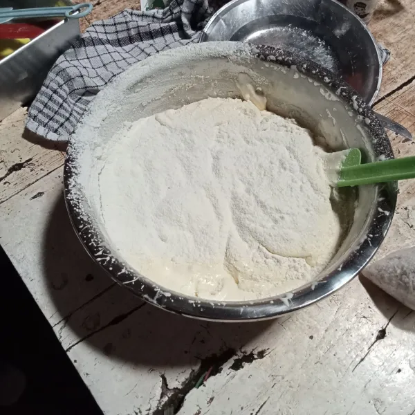 Masukan susu bubuk dan tepung sambil diayak. Mixer dengan kecepatan rendah hingga tercampur. Masukan margarin, aduk dengan spatula hingga tercampur rata.