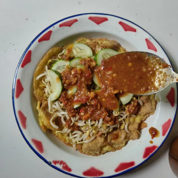Masukkan tahu telur, taoge dan timun ke dalam piring.
Terakhir siram dengan sambal kacang, sajikan.
