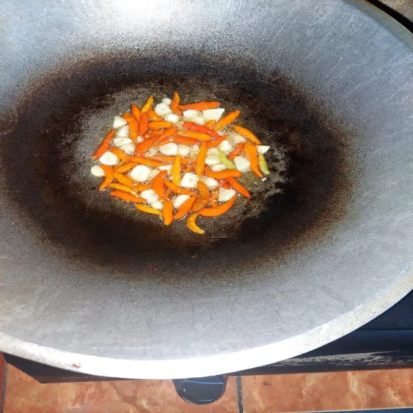 Panaskan minyak goreng secukupnya. Goreng bawang putih dan cabe rawit merah sampai layu. Angkat