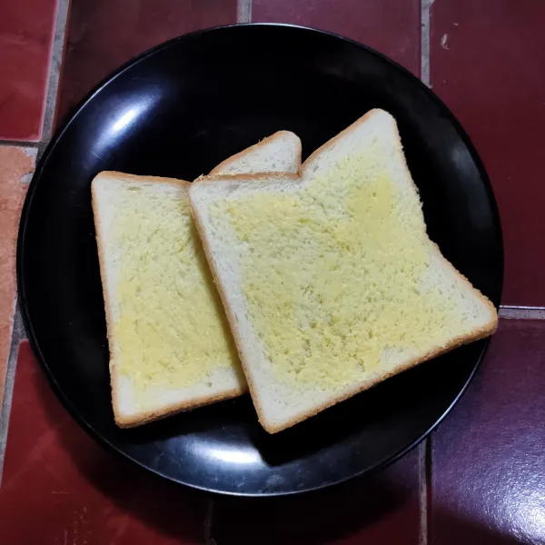 Oles roti dengan margarin lalu sisihkan