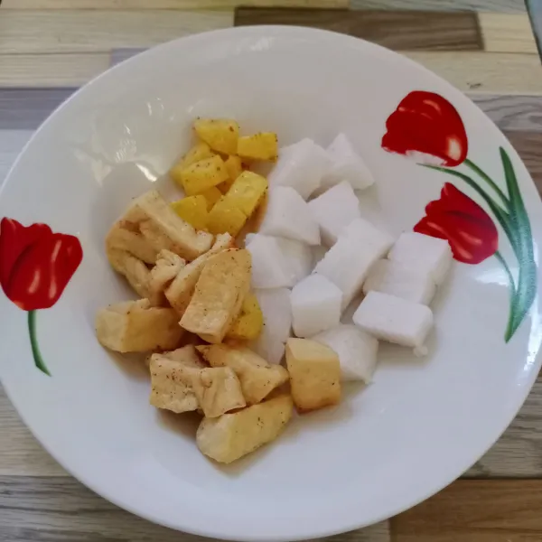 Tata lontong, tahu goreng dan kentang goreng di piring saji.