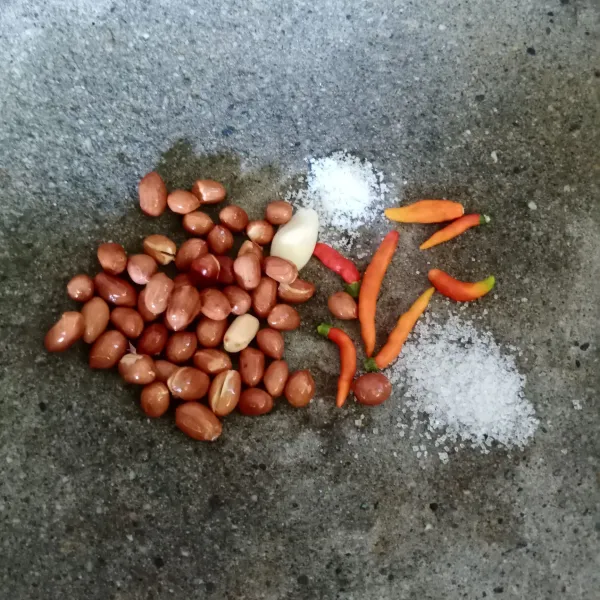 Dalam cobek masukkan kacang tanah, cabe rawit, bawang putih, gula dan garam.