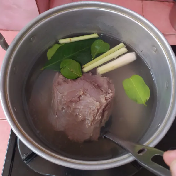 Rebus daging sapi bersama daun salam, daun jeruk dan serai.