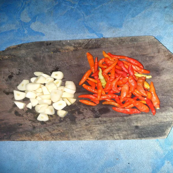 Potong potong bawang putih dan tusuk /sayat sedikit cabe rawit merah, supaya tidak meledak saat di goreng.