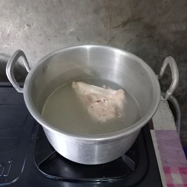 Rebus ayam sebentar saja, kemudian buang airnya agar tidak amis. Rebus lagi dengan 1 liter air sampai empuk.