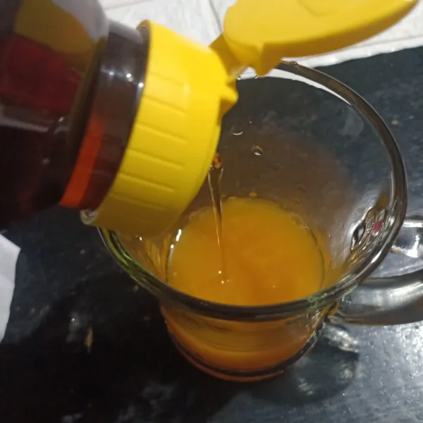 Masukkan air jeruk dalam gelas lalu tambahkan madu, aduk rata.