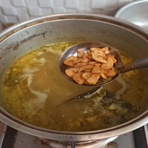 Masukkan bawang putih goreng 1 sdm kedalam kuah kaldu, sisanya untuk buat koya