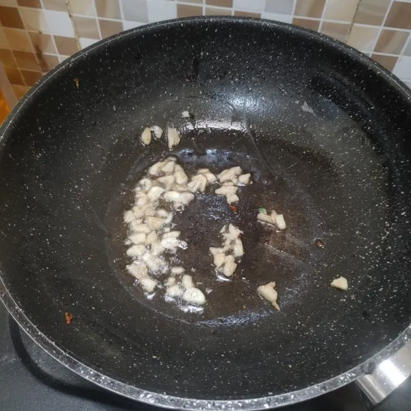 Panaskan minyak dan tumis bawang putih hingga harum.