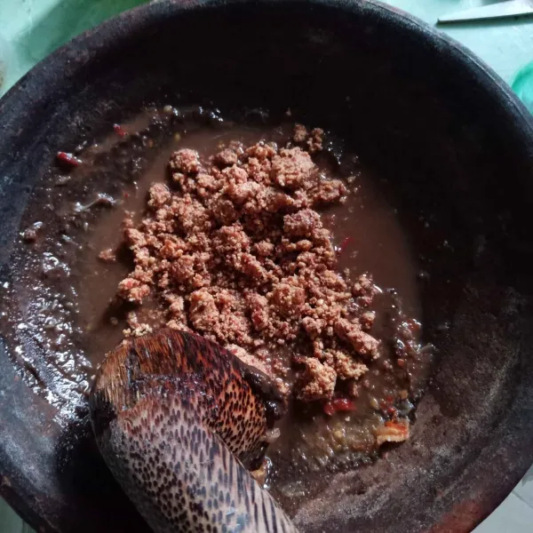 Masukkan petis, lalu kacang tanah dan haluskan.