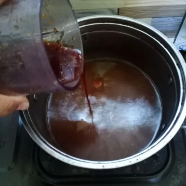 Masak air dan asam Jawa. Saat hampir mendidih, masukkan campuran gula merah dan cabai.