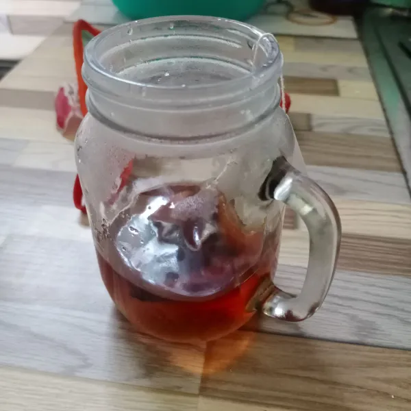 Masukkan air panas dan teh celup ke dalam gelas.