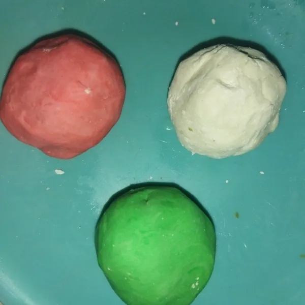 Lalu bagi adonan menjadi 3 bagian, 1 bagian dibiarkan berwarna putih, 1 bagian diberi pewarna hijau dan 1 bagian lagi diberi pewarna merah.
