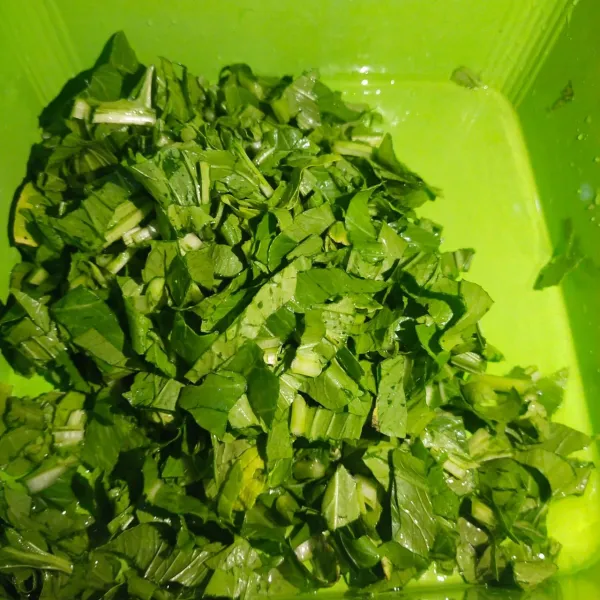 Langkah yang pertama, cuci bersih sayur sawi hijau hingga bersih dan iris tipis tipis sesuai selera.