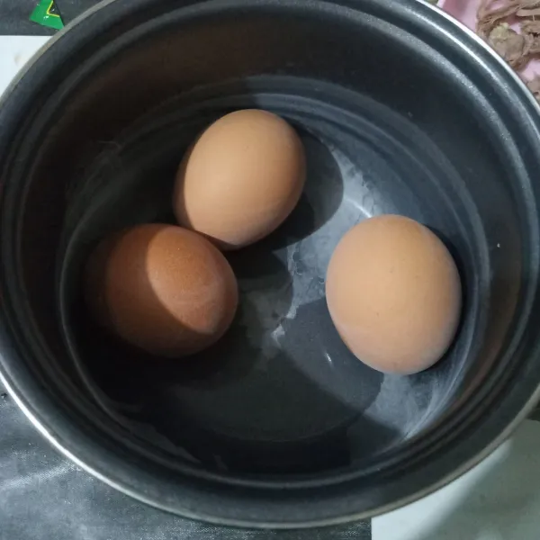 Rebus telur hingga matang lalu kupas.