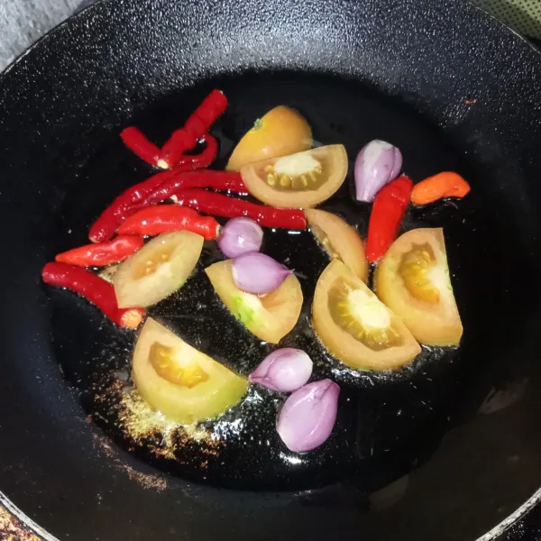 Membuat sambal, goreng cabai, bawang merah dan tomat hingga layu.