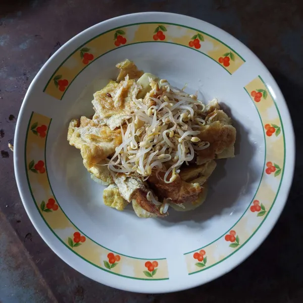 Siapkan piring saji, masukkan lontong, tahu goreng, telur dadar dan taoge rebus.