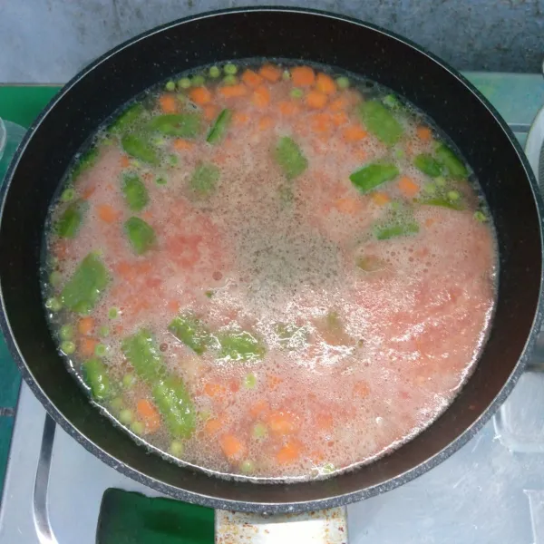 Masukkan bumbu halus, jus tomat, gula, dan garam, lalu aduk rata. Masak sampai mendidih.