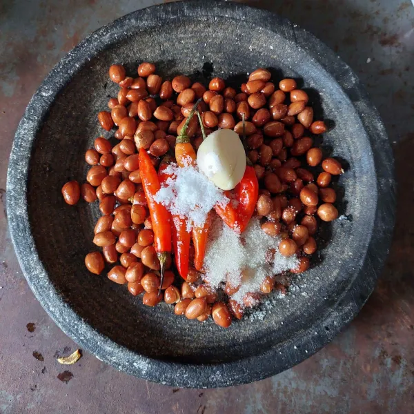 Goreng kacang tanah, tambahkan cabe rawit, bawang putih, garam dan gula pasir, haluskan.