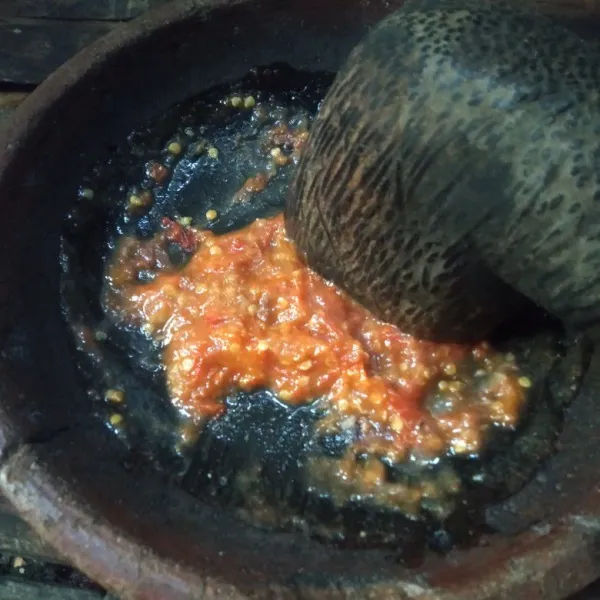 Setelah itu ulek bahan sambal hingga halus, siram dengan minyak panas, sisihkan.