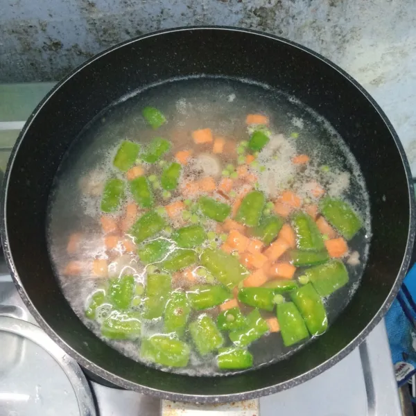 Rebus air sampai mendidih, masukkan ayam dan rebus sampai empuk. Masukkan wortel dan kercis, lalu rebus sampai mendidih dan empuk.