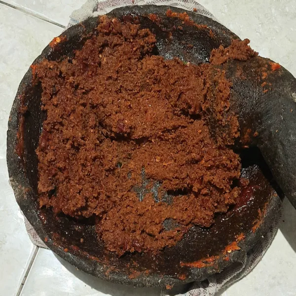 Haluskan atau ulek kacang tanah, cabai rawit, cabai merah, bawang putih, kencur, daun jeruk, gula merah, gula pasir, garam, asam jawa sampai tercampur rata dan halus.