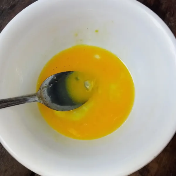 Pecahkan telur, lalu bumbui dengan garam, lada bubuk, dan kaldu jamur, kemudian kocok lepas.