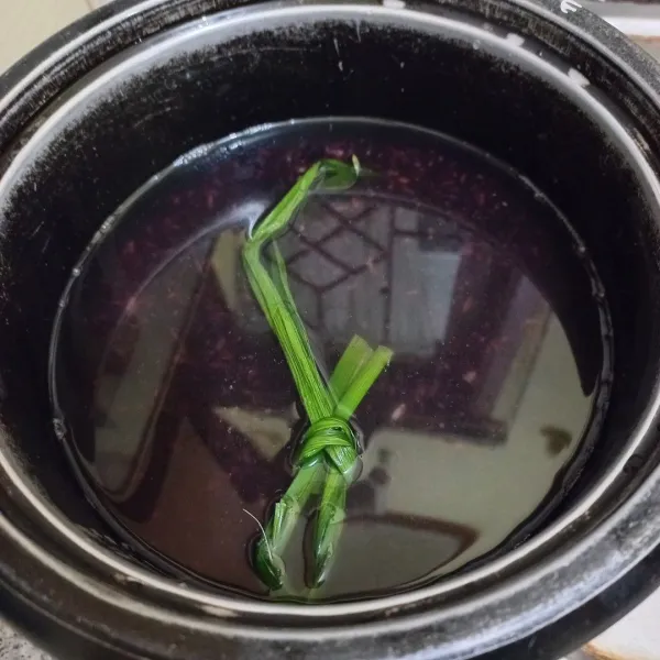 Tuang ketan hitam pada panci, tambahkan air secukupnya dan daun pandan, masak hingga hampir empuk (tuang air secara bertahap sesuai kebutuhan).