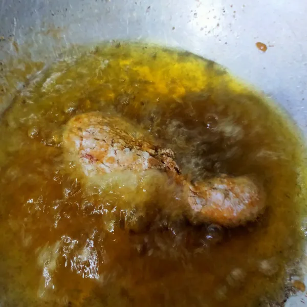 Dalam wajan panaskan minyak lalu goreng ayam hingga matang dengan api sedang.
