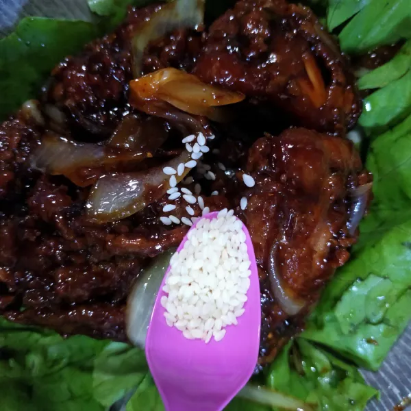 Sajikan ayam bulgogi dalam piring saji, taburi dengan wijen sangrai. Ayam bulgogi siap dinikmati bersama nasi hangat dan telur mata sapi.