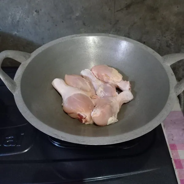 Cuci ayam sampai bersih. Masukkan ayam ke dalam wajan.