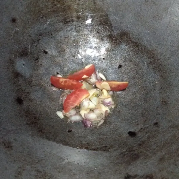 Tumis bawang merah, bawang putih dan tomat yang sudah di potong sampai layu.