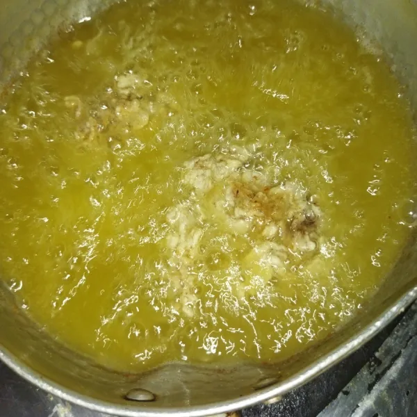 Lalu masukkan daging ayam yang sudah dilapisi tepung kedalam minyak goreng yang sudah panas, goreng dengan minyak banyak, hingga daging ayam terendam, saya menggorengnya dengan menggunakan panci kecil.