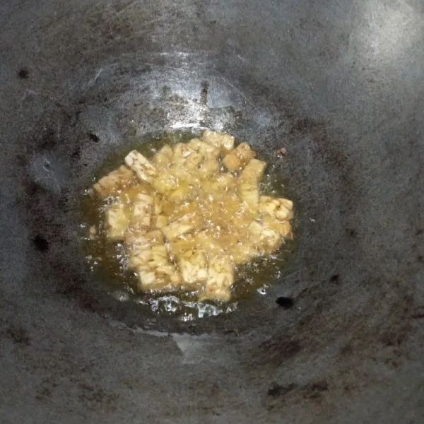 Potong tempe sesuai selera, kemudian goreng pada minyak panas cukup setengah matang, angkat dan sisihkan.