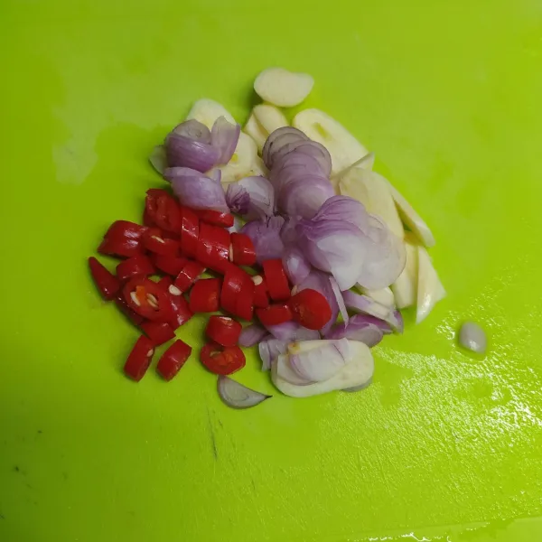 Iris tipis bawang merah, bawang putih dan iris kasar cabe merah. Kemudian panaskan secukupnya minyak goreng, tumis sampai layu dan harum.