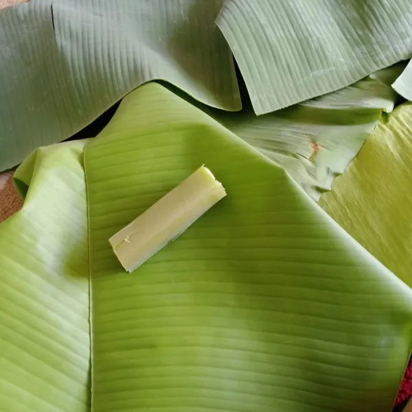 Siapkan daun pisang dan sepotong pelepah daun pisang kira-kira 7 cm.