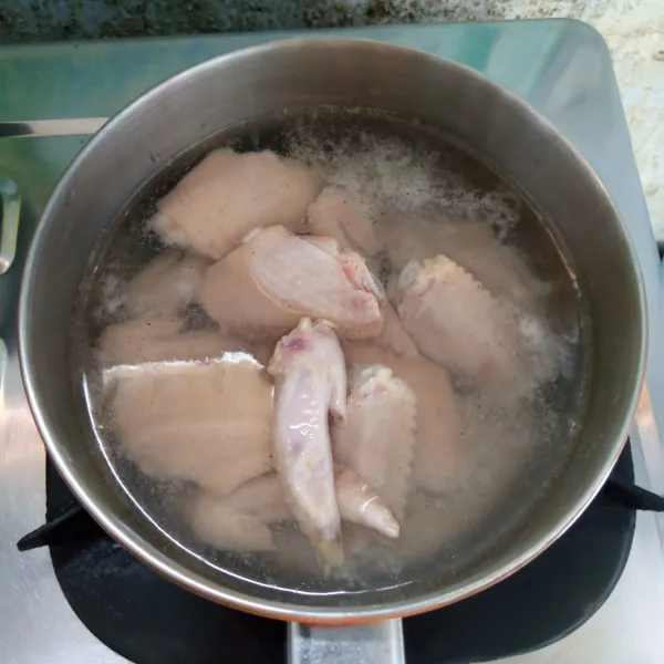 Rebus air, garam dan lada bubuk sampai mendidih. Masukkan sayap ayam. Rebus sampai mendidih. Angkat dan tiriskan.