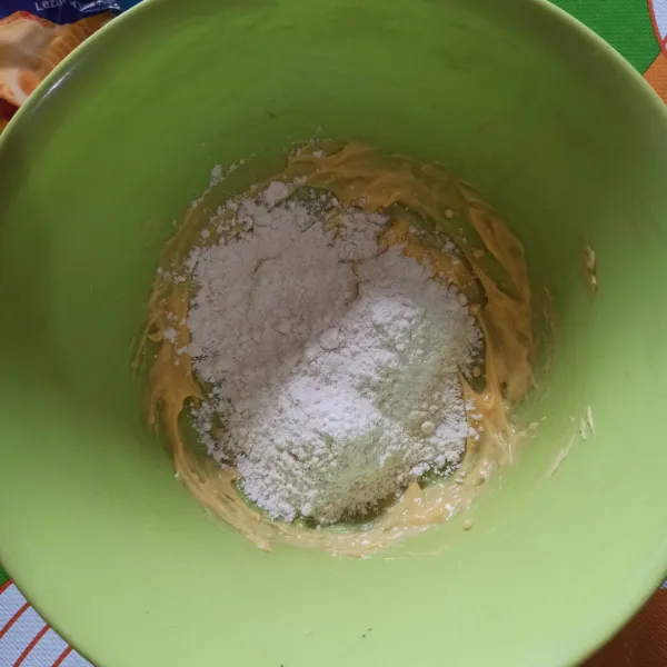 Campur margarin dan kental manis dengan bantuan whisk. Lalu masukkan tepung, aduk hingga membentuk adonan.